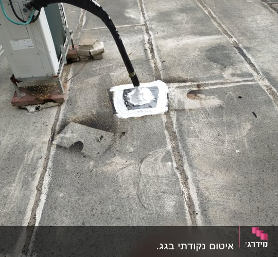צינור אטום בחומר לבן על גג בטון